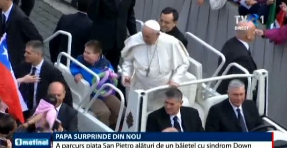 Papa Francisc în papamobil alături de un băiețel cu sindrom Down