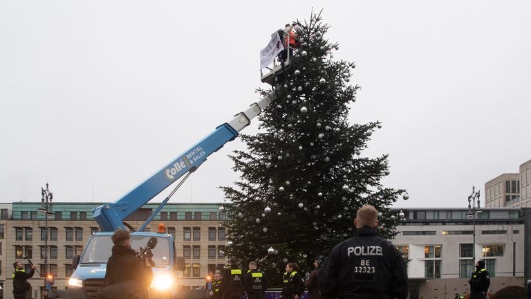 Activiştii pentru climă au tăiat cu fierăstrăul vârful pomului de Crăciun din faţa Porţii Brandenburg